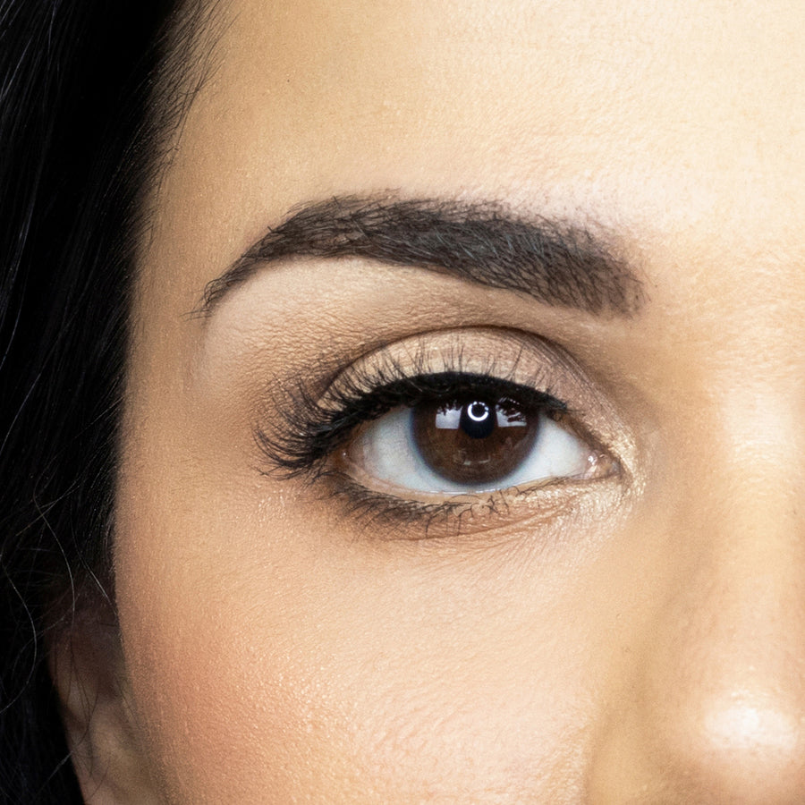 Suntarah Beauty 3D Faux Mink False Strip Eyelash in Style F-101. Close up picture of young woman wearing lash looking straight ahead.