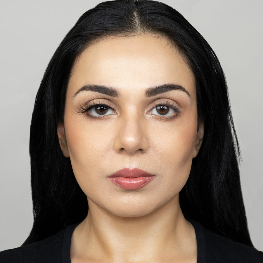 Full face of young beautiful woman wearing Suntarah Beauty Premium Synthetic Strip Eyelash in Style S-221 on right eye only.  There is a significant difference in appeal between both her eyes.  Her right eye is glamorously accentuated with a wispy, sexy, cat-eye like false strip lash.